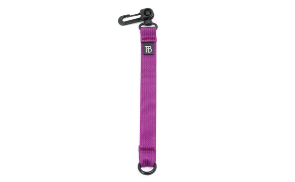An 8-inch Ultraviolet (purple) Key Strap with a snaphook at one end and an o-ring at the other.